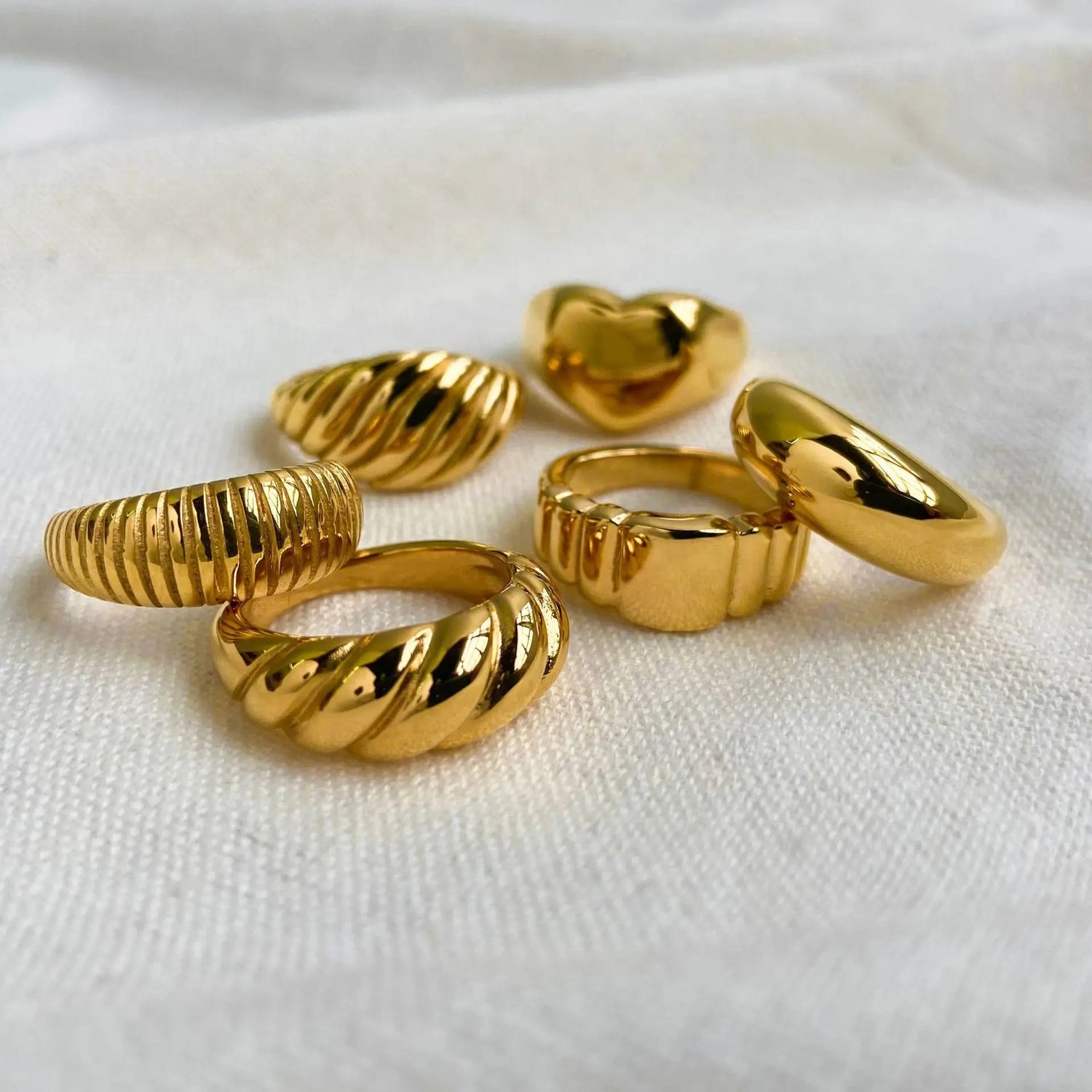 Beautiful gold rings on a white ceramic dish
